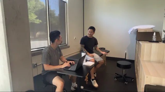 Dr. Michael Yip consulting with a patient at AdaptivMVMT Physical Therapy