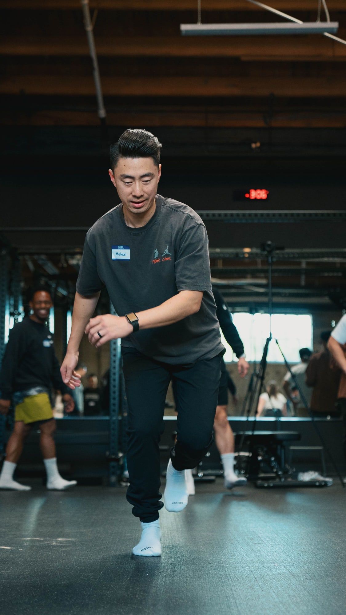Dr. Michael Yip mid-step during a movement drill, wearing a name tag