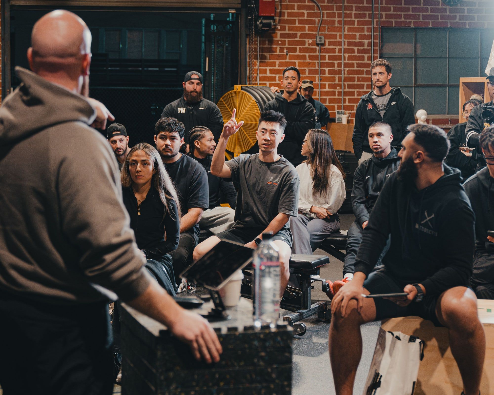 Dr. Michael Yip seated in a seminar with his hand raised